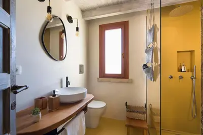 a bathroom with a sink and a toilet and a mirror at Villa Disa Cala Bianca in Castellammare del Golfo