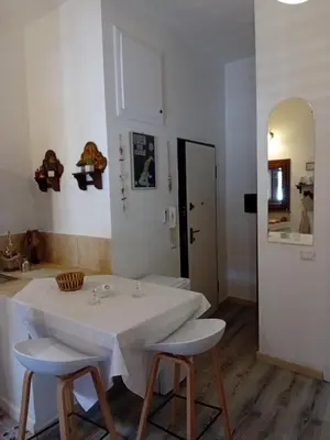 a white table and two stools in a room at Papireto house in Palermo