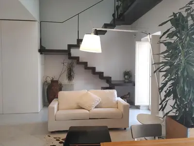 a living room with a couch and a staircase at Loft in Vucciria in Palermo
