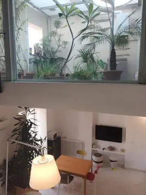 a living room with a table and potted plants at Loft in Vucciria in Palermo