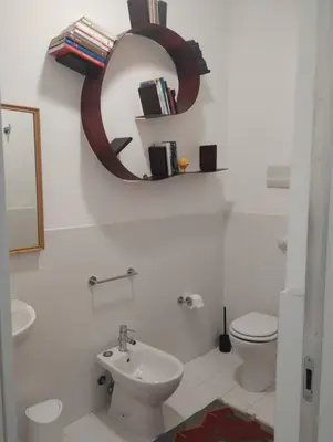 a bathroom with a sink and a toilet and a mirror at Loft in Vucciria in Palermo