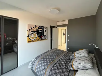 a bedroom with a bed and some pictures on the wall at Villa Nanni Contemporary, Pool and Garden in Castellammare del Golfo
