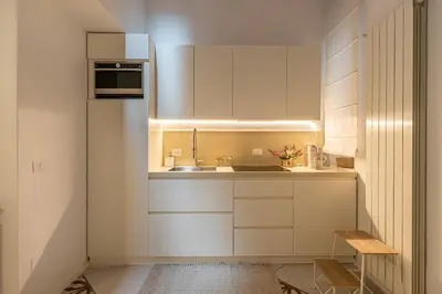 a small kitchen with white cabinets and a sink at La casa nel baglio in Palermo