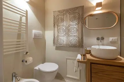 a bathroom with a sink and a toilet and a mirror at La casa nel baglio in Palermo