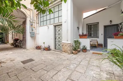 a courtyard with a door and potted plants at La casa nel baglio in Palermo