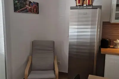 a chair sitting in a room with a refrigerator at Casa Maielli in Palermo