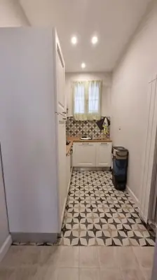 a kitchen with a black and white tiled floor at L'ùoro Apartment in Carini