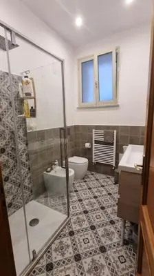 a bathroom with a shower and a toilet and a sink at L'ùoro Apartment in Carini