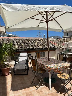 a table and chairs with an umbrella on a patio at Appartamento Palermo Sole di Sicilia in Palermo