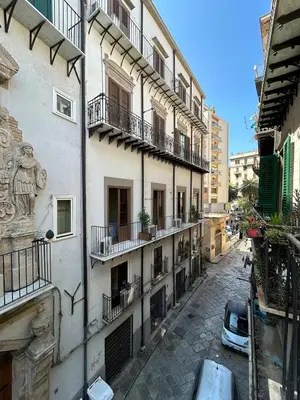 an alley with buildings and a car parked on the street at Appartamento Palermo Sole di Sicilia in Palermo