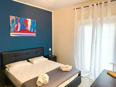 a bedroom with a bed and a blue wall at La Casetta di Ale - By Rental BeB Italy - in Palermo