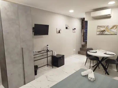 a table in a room with a tv on a wall at Avusa Home in Palermo