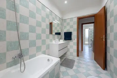 a bathroom with a tub and a sink and a tv at Villino Giovanna a Trabia a 200 mt dal mare in Trabia