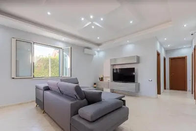 a living room with a couch and a flat screen tv at Villino Giovanna a Trabia a 200 mt dal mare in Trabia