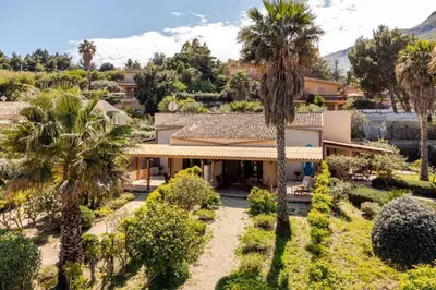 an aerial view of a house with palm trees at Villa Capreria by Sicily Travelling Villas in Scopello