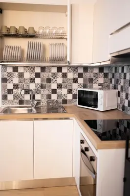 a kitchen with white cabinets and a microwave at Maqueda Luxury Suite & Home in Palermo
