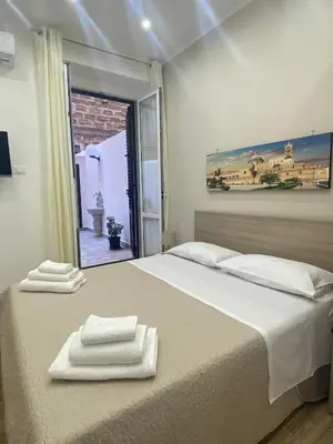 a bedroom with a bed with two towels on it at Myrica House in Palermo