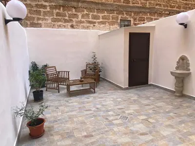 a patio with chairs and a table and a door at Myrica House in Palermo
