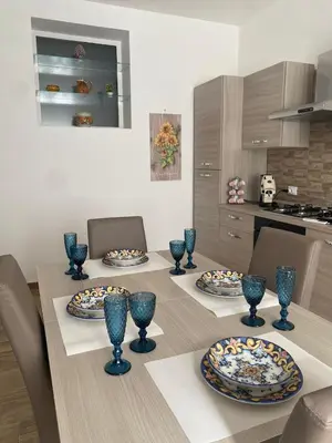 a kitchen with a table with blue vases on it at Myrica House in Palermo