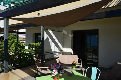 a patio with a table and chairs and an umbrella at Casa Paola in Monreale