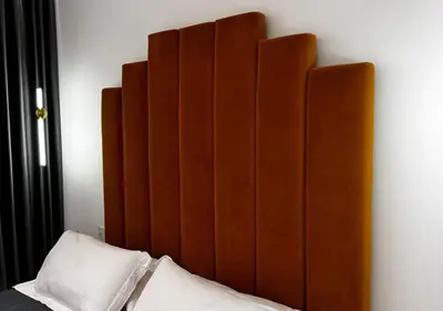 a bed with a large wooden headboard on a wall at Alba Gold LUXURY SUITE & VILLA in Cefalù