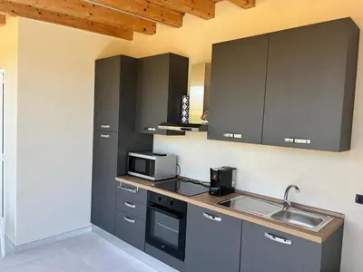 a kitchen with gray cabinets and a sink at Alba Gold LUXURY SUITE & VILLA in Cefalù