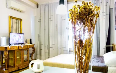 a living room with a vase of flowers on a table at Suite in Center Apartments in Palermo
