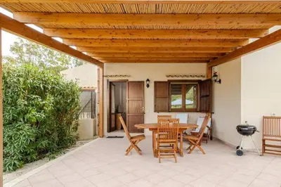 a patio with a table and chairs and a grill at Villa Berretta by Sicily Travelling Villas in Scopello