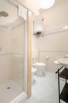 a bathroom with a shower and a toilet and a sink at Villa Uzzo by Sicily Travelling Villas in Scopello