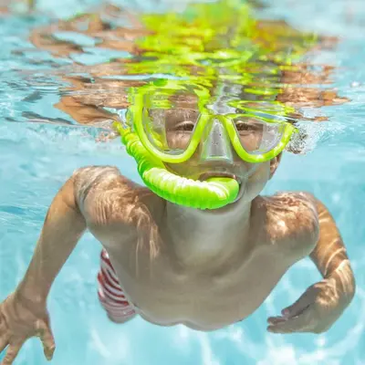 a man in a swimming pool wearing a snorkel and goggles at Villa Uzzo by Sicily Travelling Villas in Scopello