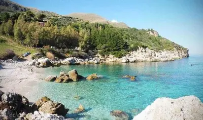 a body of water with rocks and a beach at Villa Uzzo by Sicily Travelling Villas in Scopello