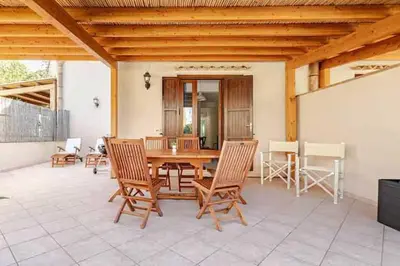 a patio with a wooden table and chairs at Villa Uzzo by Sicily Travelling Villas in Scopello