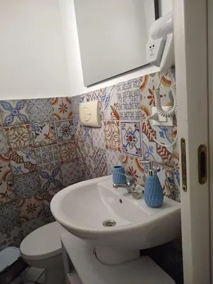 a bathroom with a sink and a toilet at Le Mura Home in Palermo