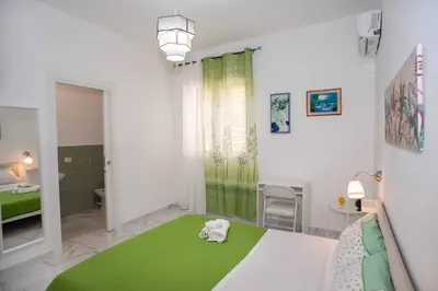 a small room with a green and white room with a bed at Azzurro Mare in Isola delle Femmine