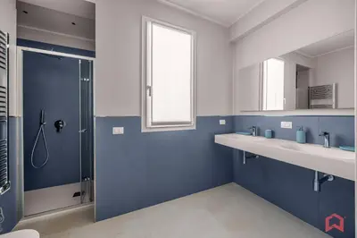a blue bathroom with two sinks and a shower at Brand New Villa with Private Heated Pool in Terrasini