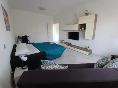 a living room with a couch and a bed at Villa Tàsca Apartment in Palermo