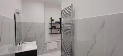 a white bathroom with a shower and a sink at Villa Tàsca Apartment in Palermo