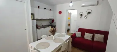 a living room with a red couch and a table at Cozy Apartment with Stunning Mountain Views in Lascari
