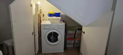 a laundry room with a washer and a staircase at Cozy Apartment with Stunning Mountain Views in Lascari
