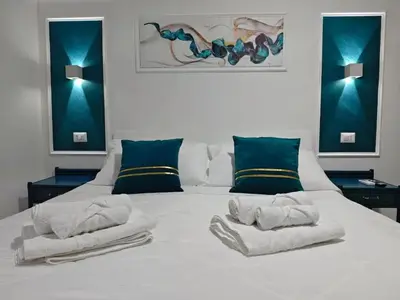 a bedroom with a white bed with towels on it at Cozy Apartment with Stunning Mountain Views in Lascari