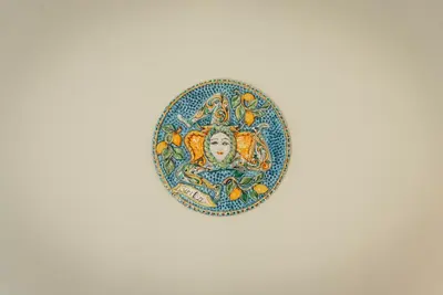 a plate with a painting of a woman with fruits at Le Meraviglie della Sicilia in Palermo