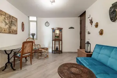 a living room with a blue couch and a table at GuestHost - The Flavour of Palermo - Kalsa Lovely Apartment in Palermo