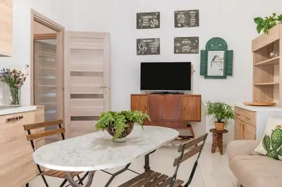 a living room with a table and a tv at GuestHost - The Flavour of Palermo - Kalsa Lovely Apartment in Palermo