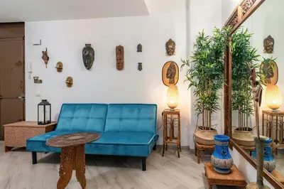 a living room with a blue couch and some plants at GuestHost - The Flavour of Palermo - Kalsa Lovely Apartment in Palermo