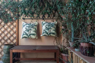 a bench with two pillows on a wall with plants at GuestHost - The Flavour of Palermo - Kalsa Lovely Apartment in Palermo