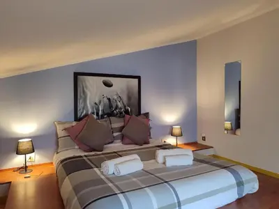 a large bed in a room with two lamps at Mansarda di Gabriella al Politeama - City center in Palermo