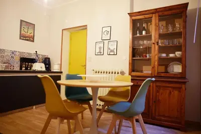 a table and chairs in a kitchen with a yellow door at Mansarda di Gabriella al Politeama - City center in Palermo