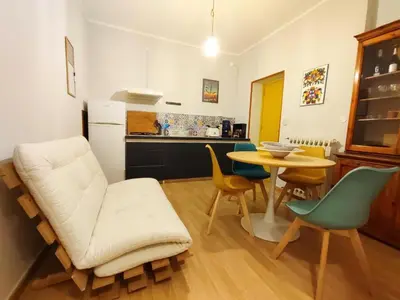 a kitchen with a table and a white couch and chairs at Mansarda di Gabriella al Politeama - City center in Palermo