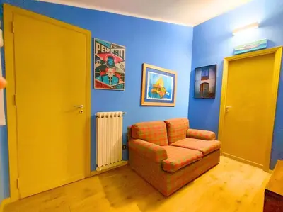 a living room with a chair and blue walls at Mansarda di Gabriella al Politeama - City center in Palermo