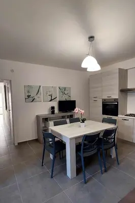 a kitchen with a white table and chairs and a kitchen with a table at Casa Vacanza Ciglietti in San Vito lo Capo